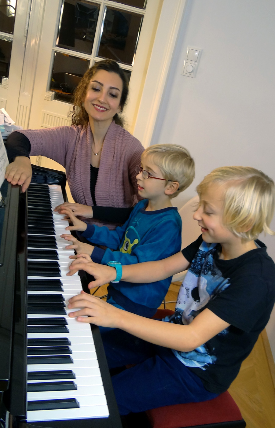 Ghoncheh mit 2 Kindern beim Klavierunterricht